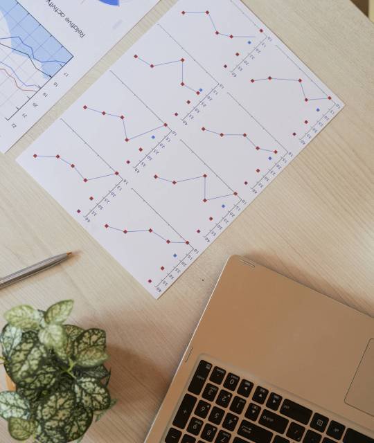 Laptop and documents with financial data on table of office manager